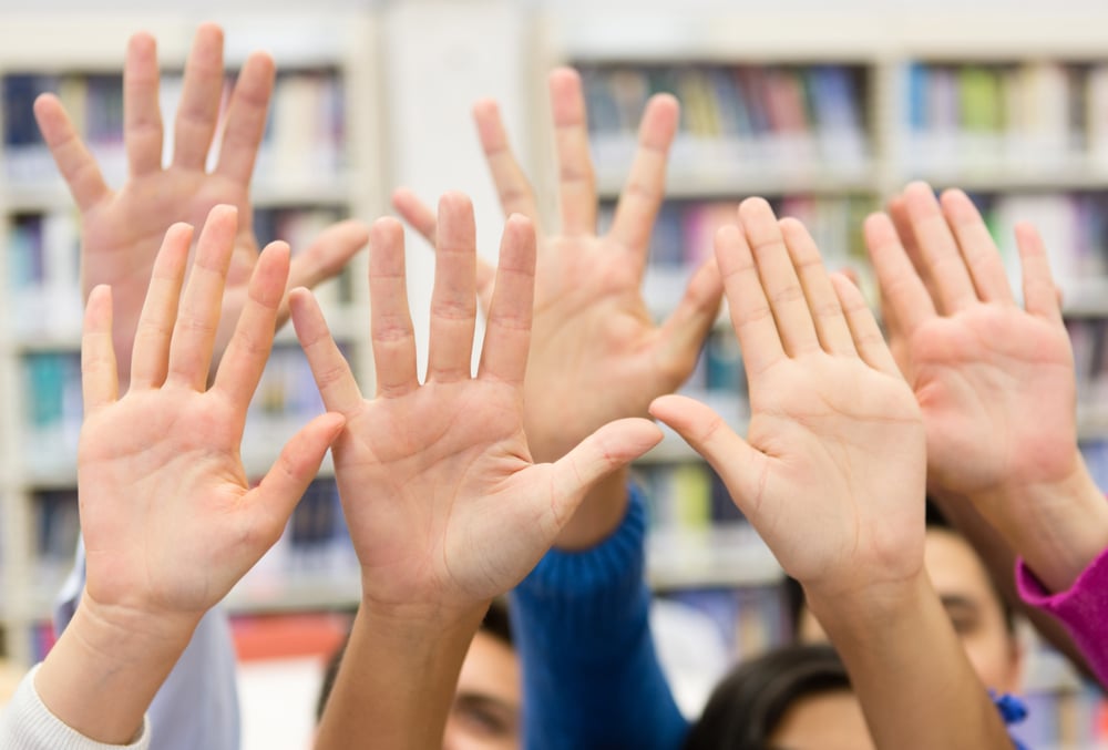 Students raising their hands to participate in class